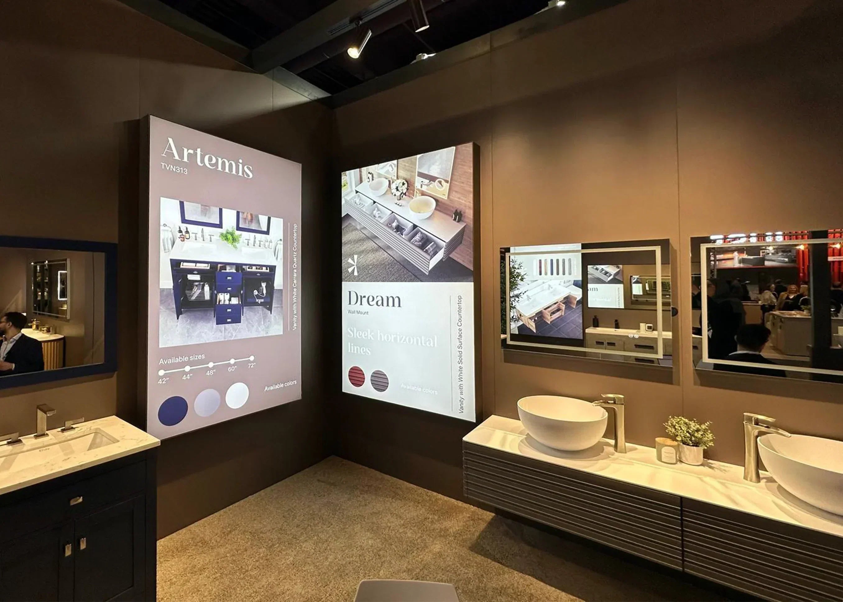 Eviva trade show display: Features 'Artemis' and 'Dream' vanities with quartz tops, sleek lines, and various sizes/colors. Showroom setting.