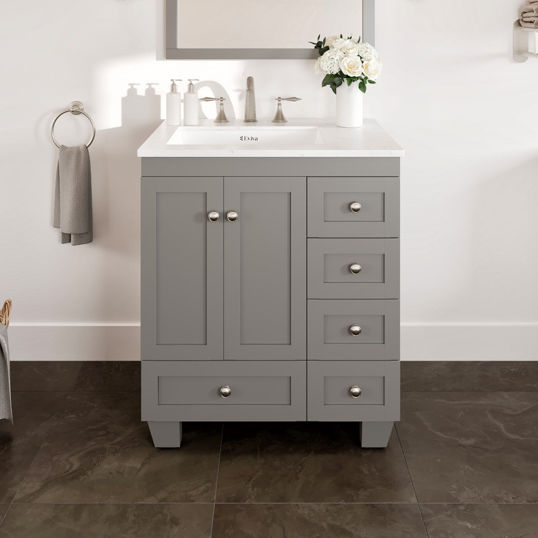 A gray single sink bath vanity with a Carrara Quartz top and undermount porcelain sink, featuring five drawers and two doors with silver hardware.