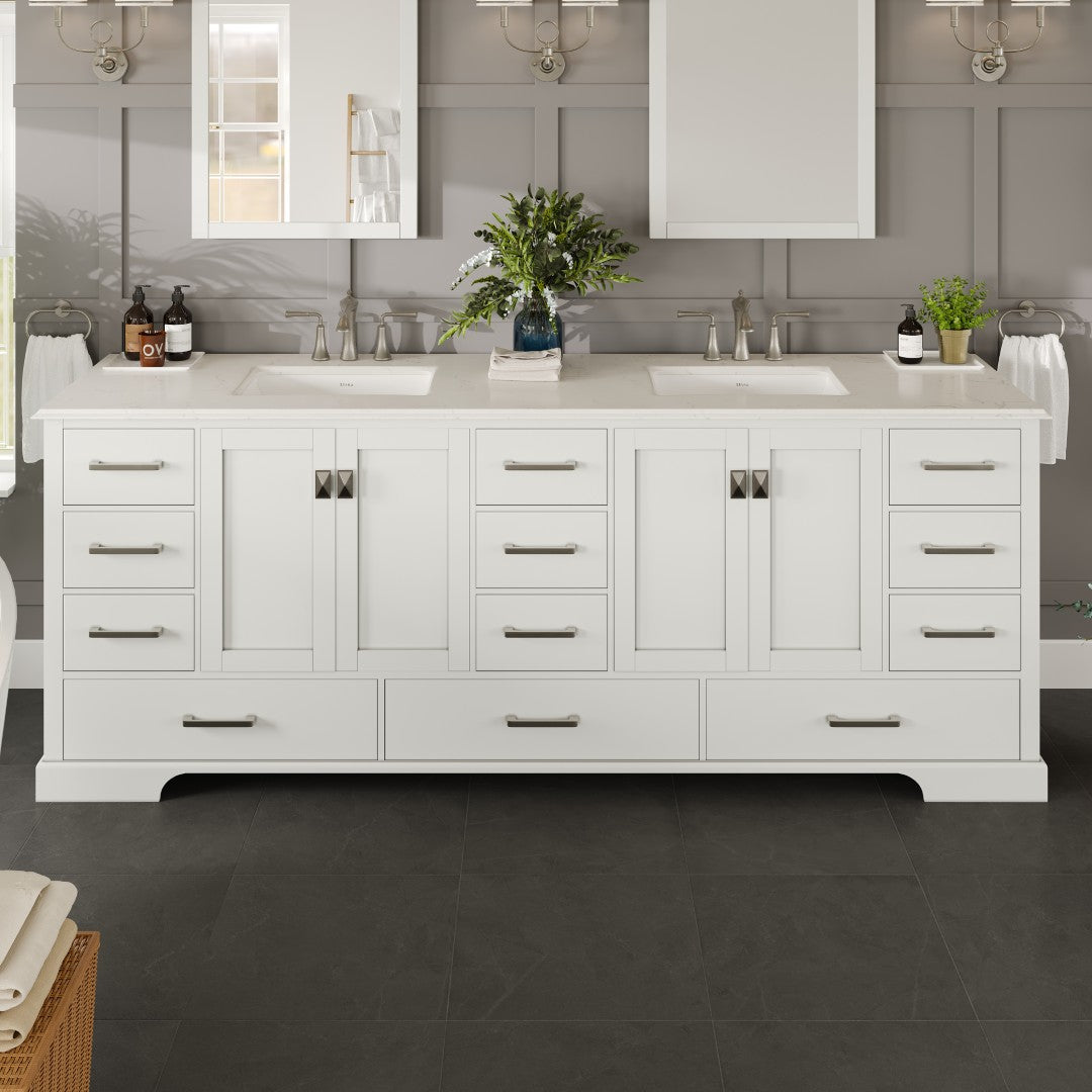 A traditional white double sink bathroom vanity with a Carrara quartz countertop and undermount porcelain sinks, featuring a wooden cabinet with drawers and storage space, displayed in a bathroom setting.