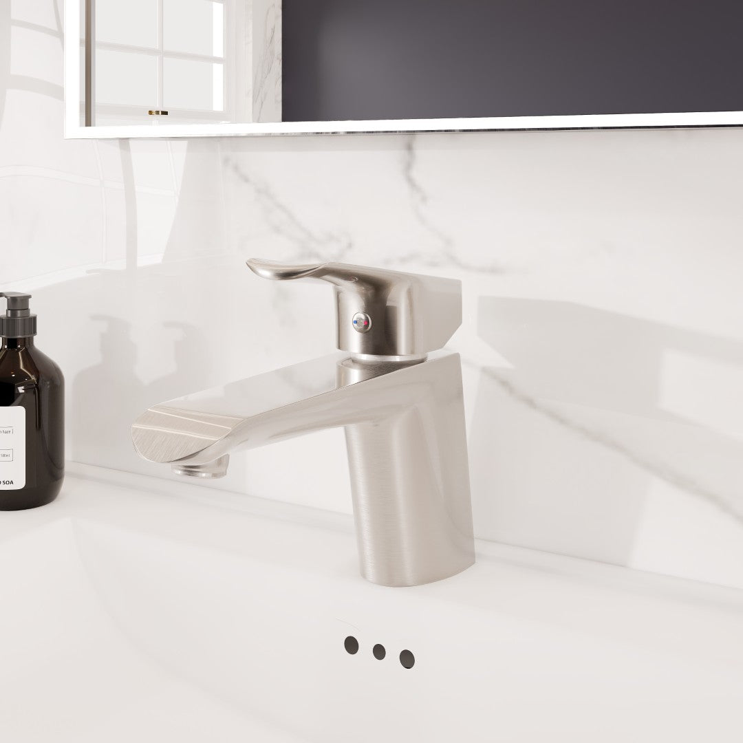 Brushed Nickel single-hole bathroom faucet with a single-lever handle and a waterfall spout, mounted on a white marble countertop.