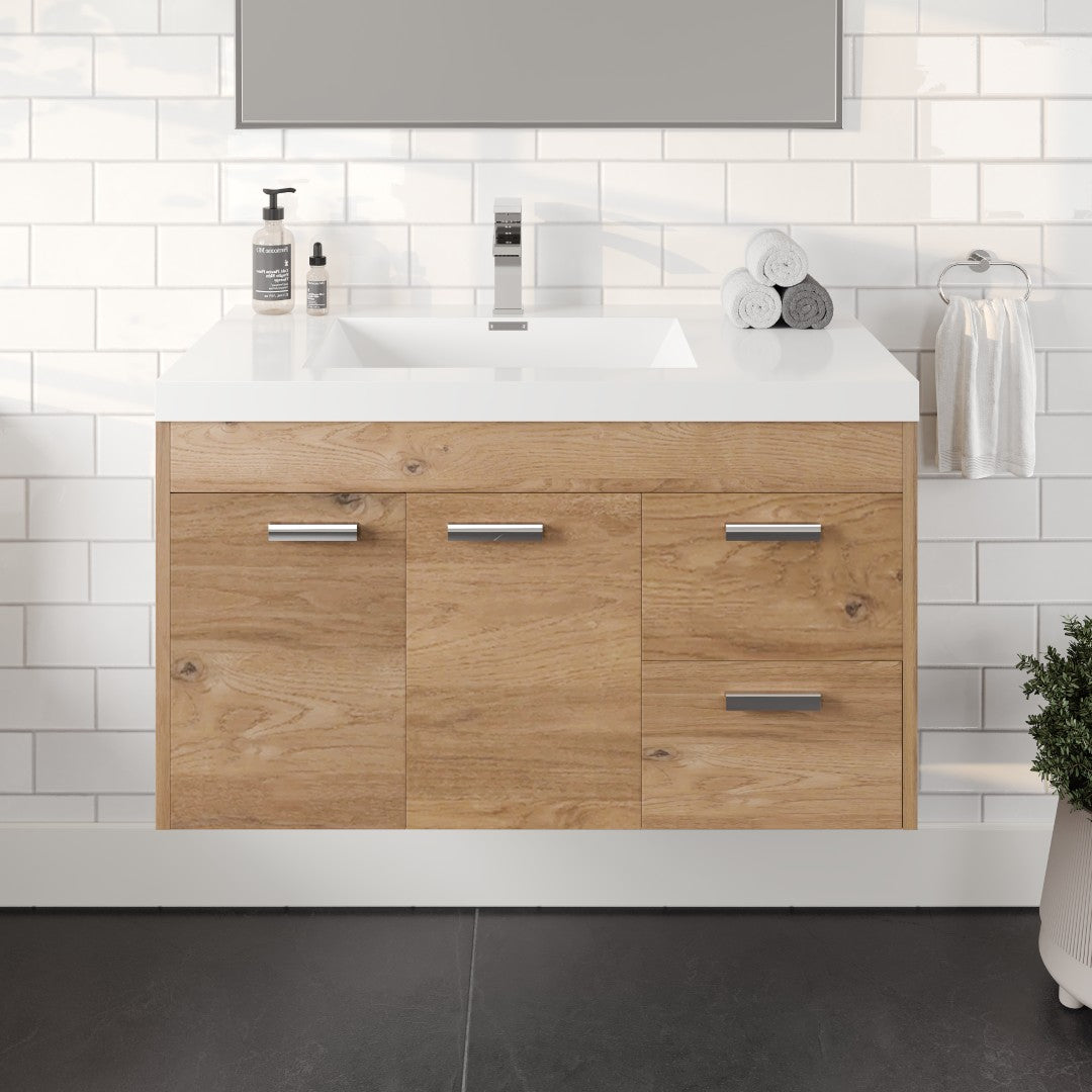 A wall-mounted Lugano 36 in. natural oak bathroom vanity with an acrylic top and integrated sink, featuring two drawers and two doors, set against a white tiled wall with a potted plant to the side.