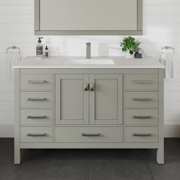 A gray single sink bath vanity with a Carrara quartz top and undermount porcelain sink, featuring multiple drawers and gold hardware.