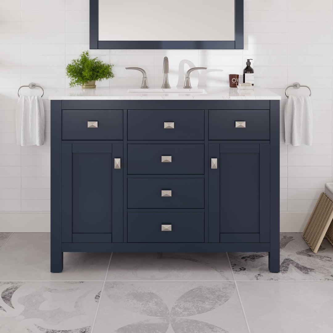 A blue single sink bath vanity with engineered stone top, undermount porcelain sink, and silver handles, displayed in a bathroom setting.