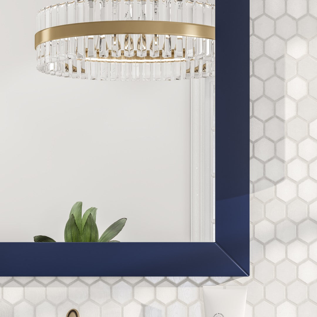 edges of dark blue framed mirror hangs on a light-colored wall