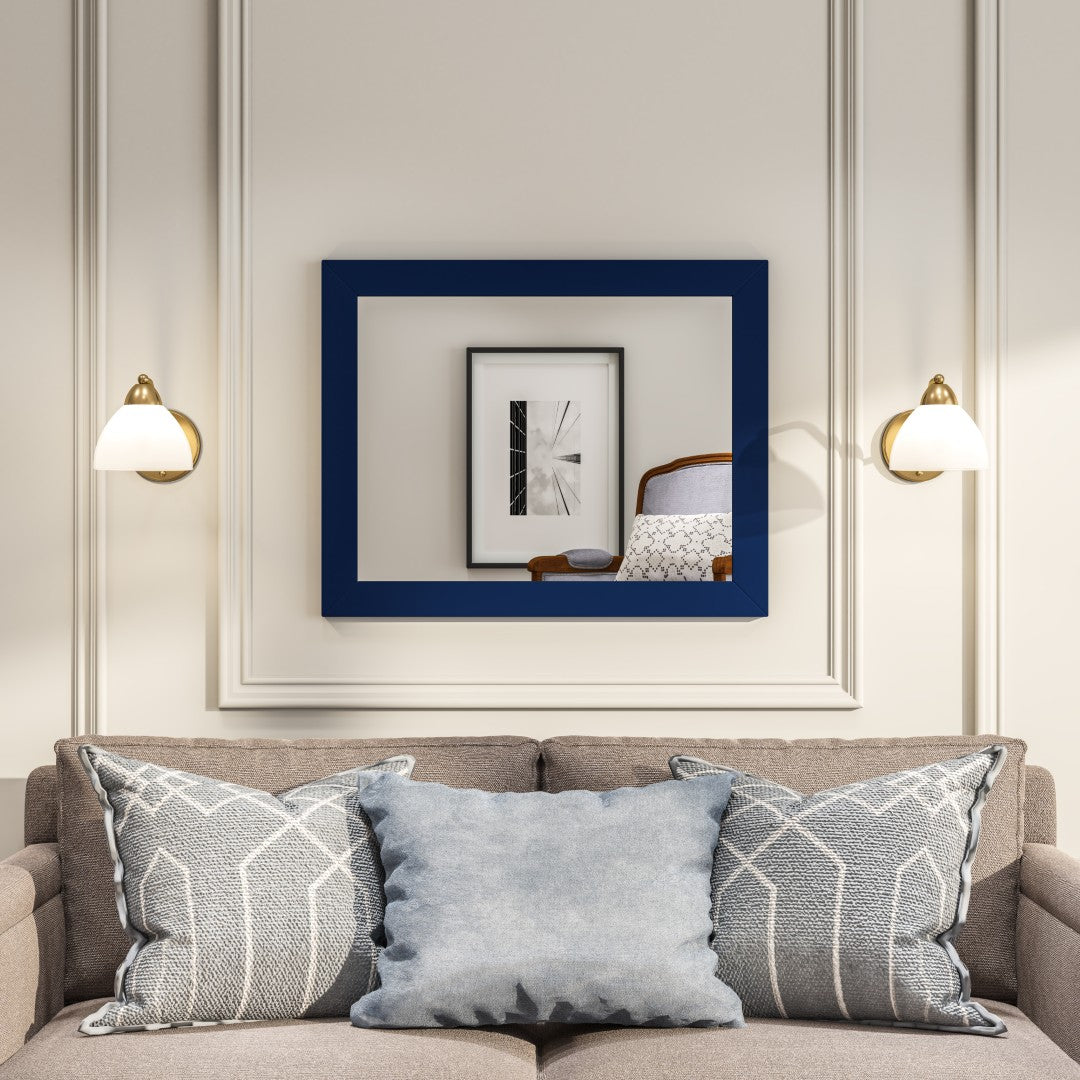 Acclaim blue rectangular wooden framed mirror hangs on a white wall above a gray sofa with patterned pillows.