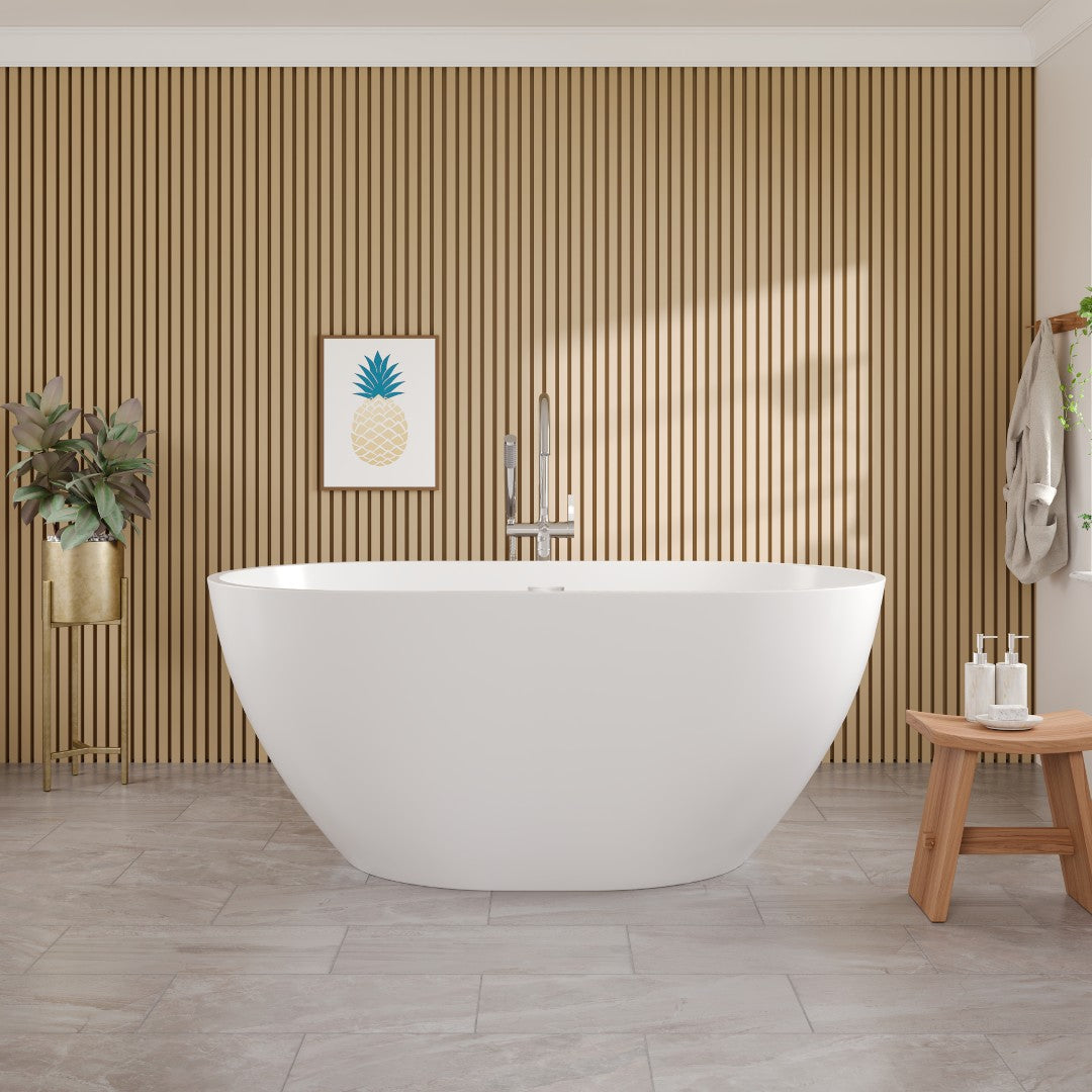 A glossy white acrylic oval freestanding bathtub placed in a bathroom setting with a wooden wall paneling, a chrome faucet, and a decorative pineapple artwork on the wall.