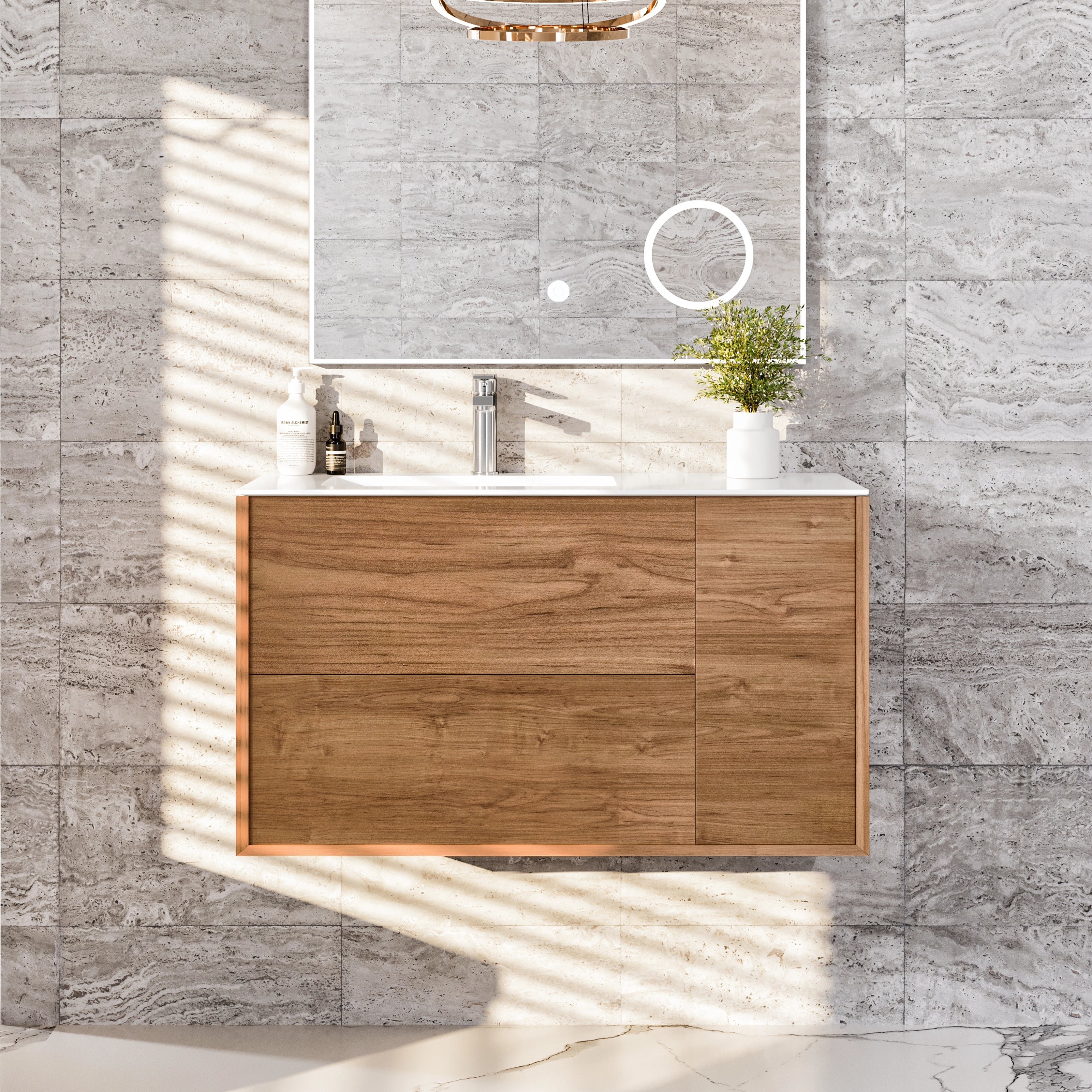 A natural oak wall mount single sink bath vanity with a solid surface top and integrated sink, displayed in a bathroom setting with a light fixture above and a plant to the side.