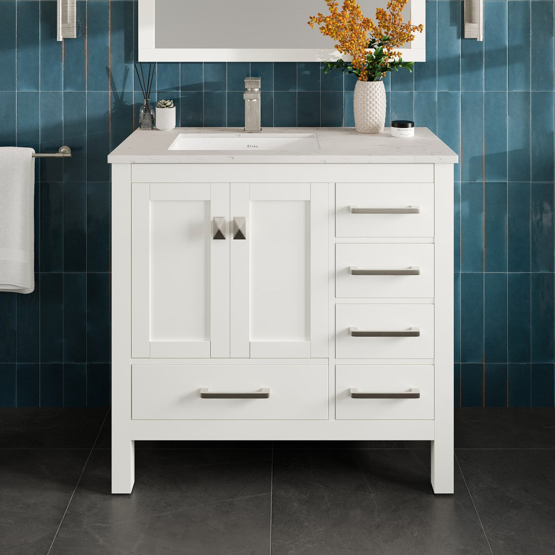 White single sink bath vanity with Carrara Quartz top and undermount porcelain sink, featuring stainless steel brushed nickel hardware, placed against a blue tiled wall with a floral arrangement on top.