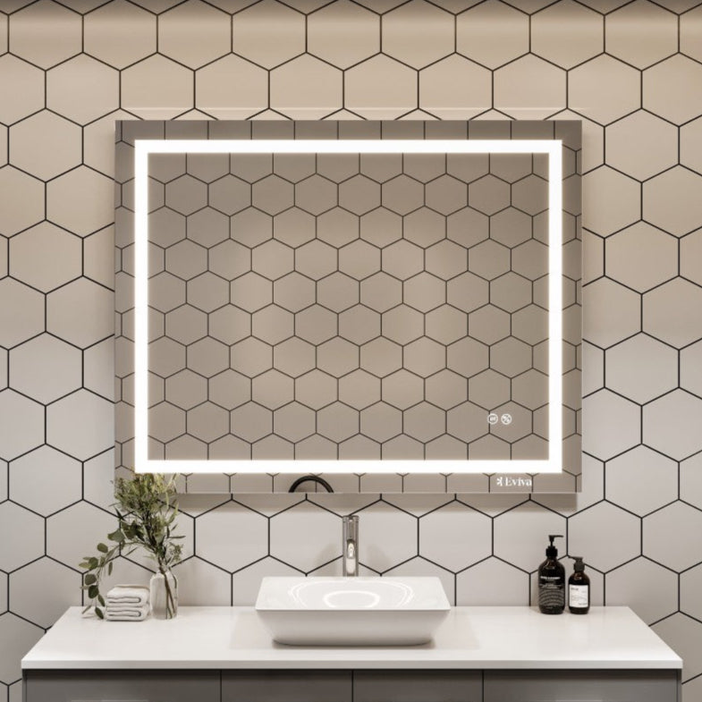 Rectangular frameless mirror with LED lighting installed above a bathroom vanity, with a modern design and anti-fog feature.