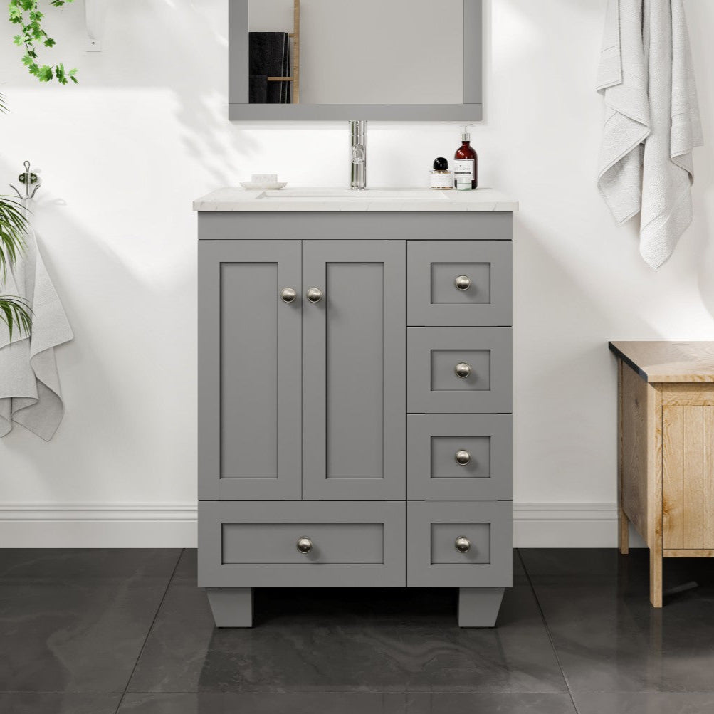A gray single sink bath vanity with a Carrara quartz top and undermount porcelain sink, featuring a mirror above and a wooden chair to the side.