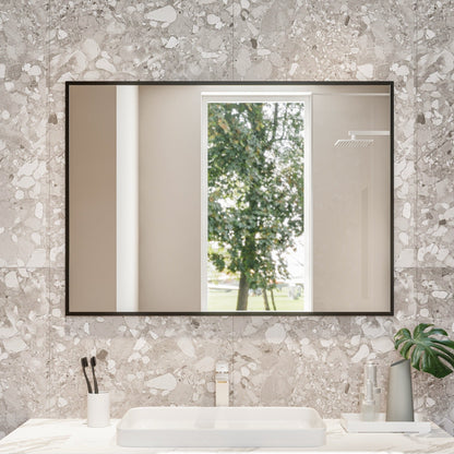 Bathroom vanity with marble countertop, mirror, and decorative items against a textured wall.