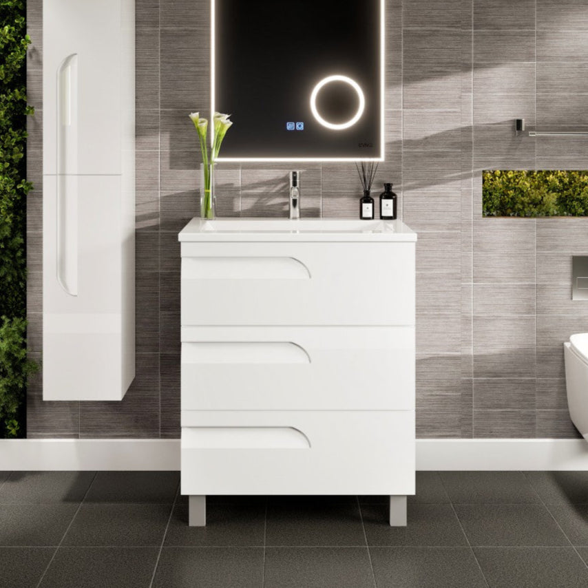 Modern white single sink bath vanity with a porcelain top and integrated sink, featuring a white finish and curved integrated drawer handles, placed in a bathroom setting with a grey wall in the background.