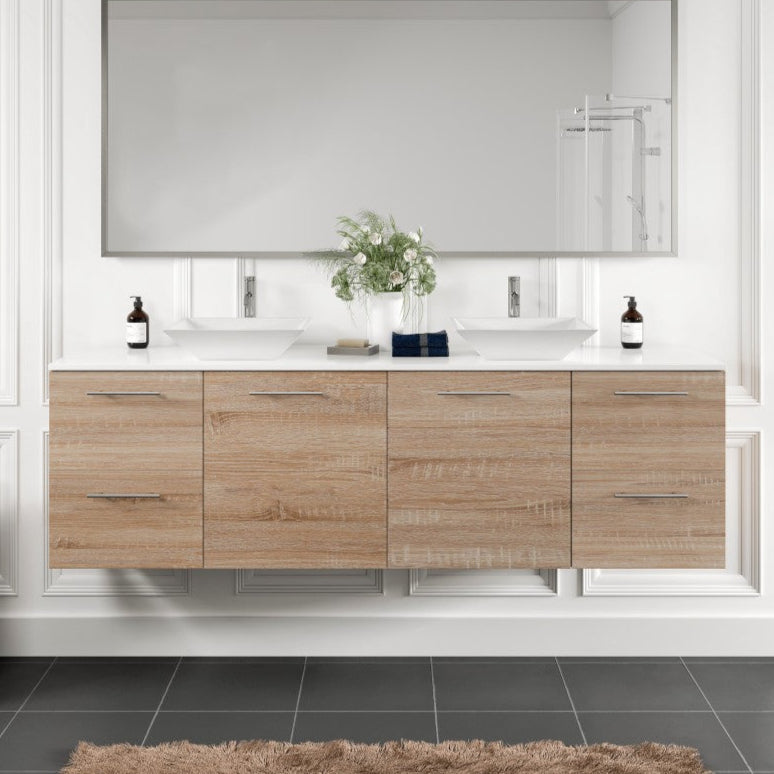 A white oak wall mount double sink bath vanity with a white quartz top and vessel porcelain sinks, displayed in a bathroom setting.