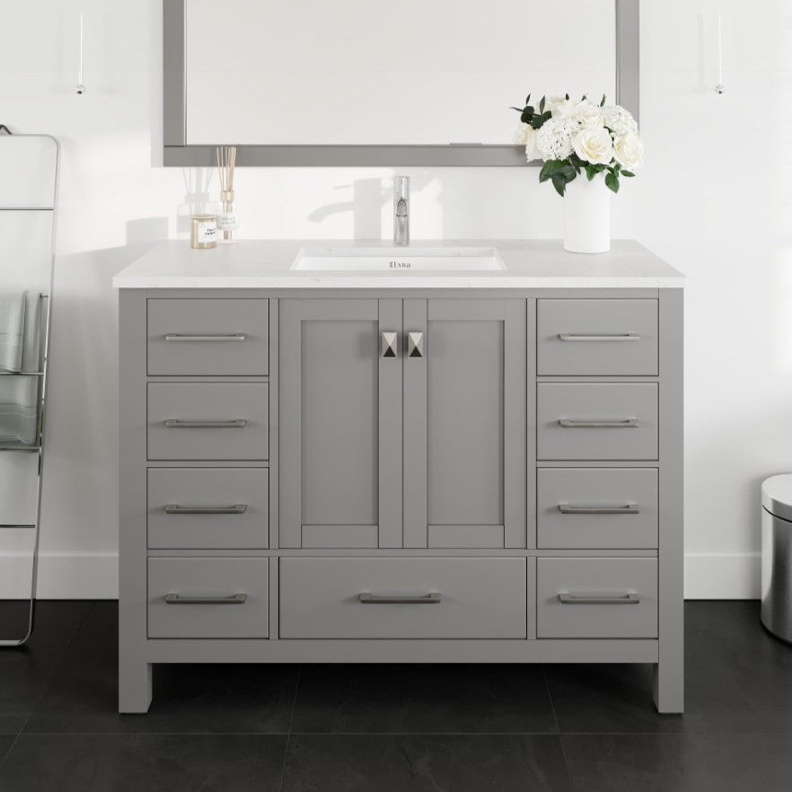 A gray single sink bath vanity with a Carrara quartz top and undermount porcelain sink, featuring stainless steel hardware.