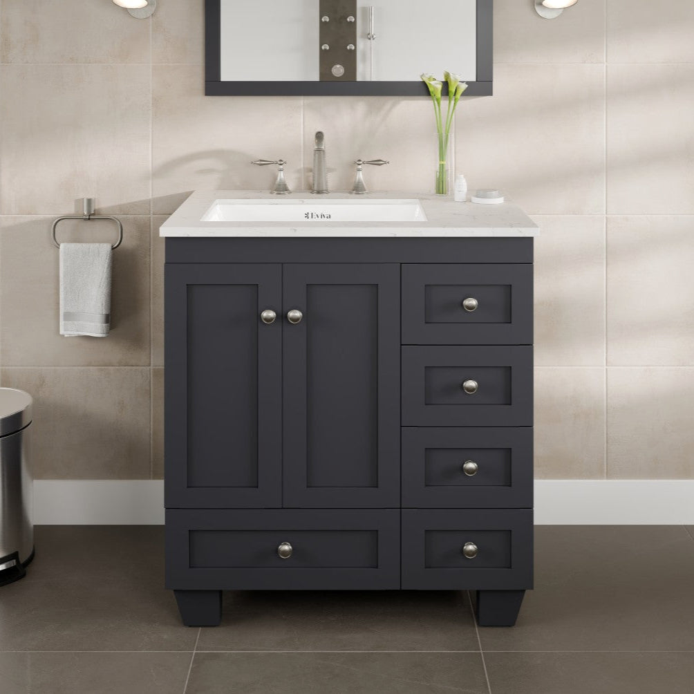A dark gray single sink bath vanity with a Carrara quartz top and undermount porcelain sink, featuring a mirror above the sink, brushed nickel hardware, and five drawers with two doors below the sink.