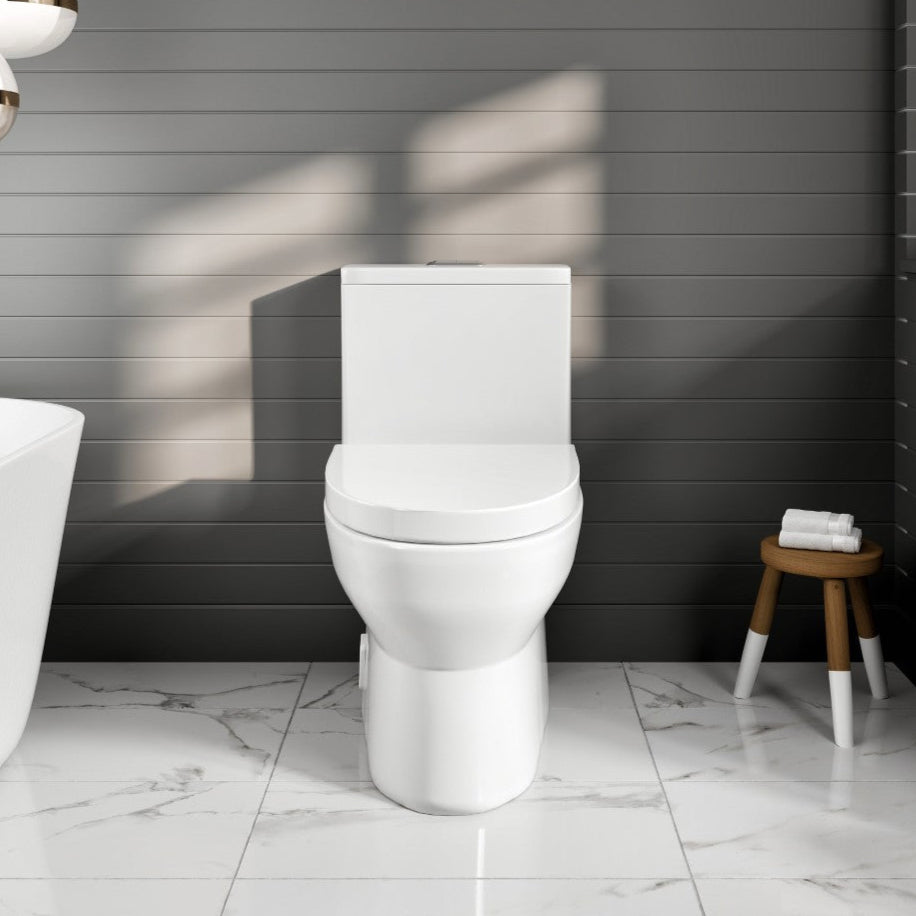 A white, floor-mounted toilet with an elongated bowl and dual flush system, displayed in a bathroom setting with gray walls, a marble floor, and a wooden stool.