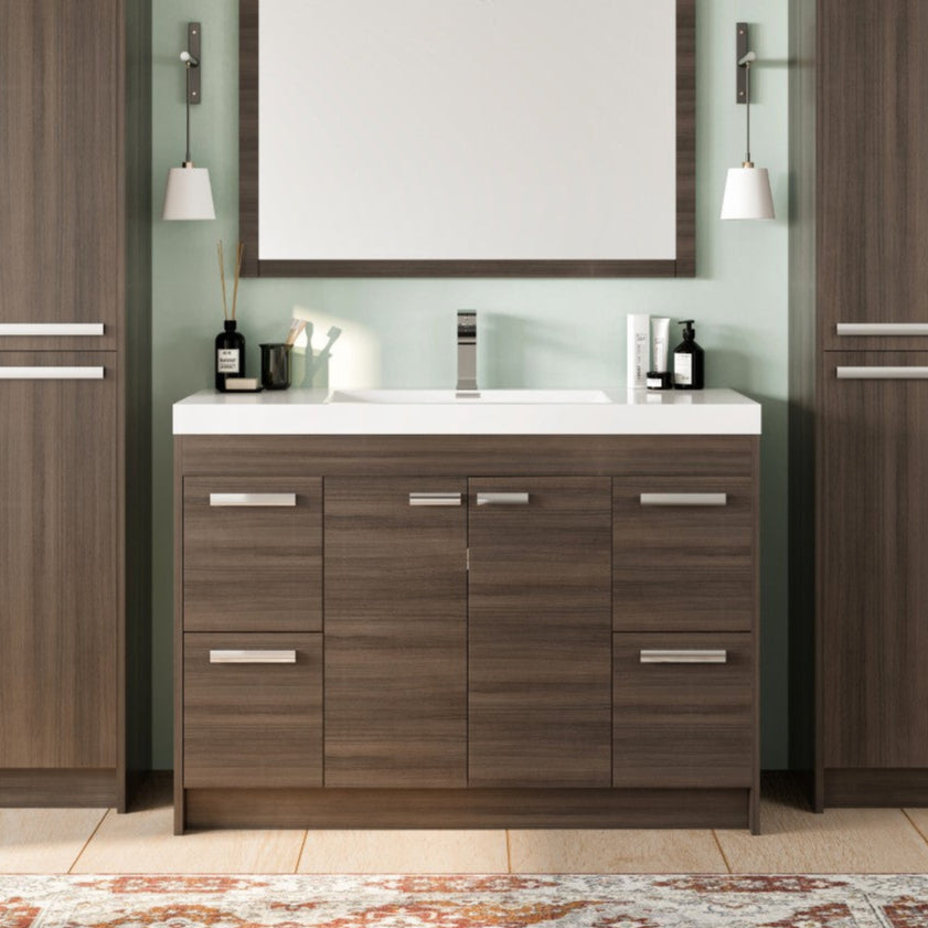 A modern Lugano 48 in. gray oak single sink bath vanity with an acrylic top and integrated sink, displayed alongside tall cabinets and a mirror.