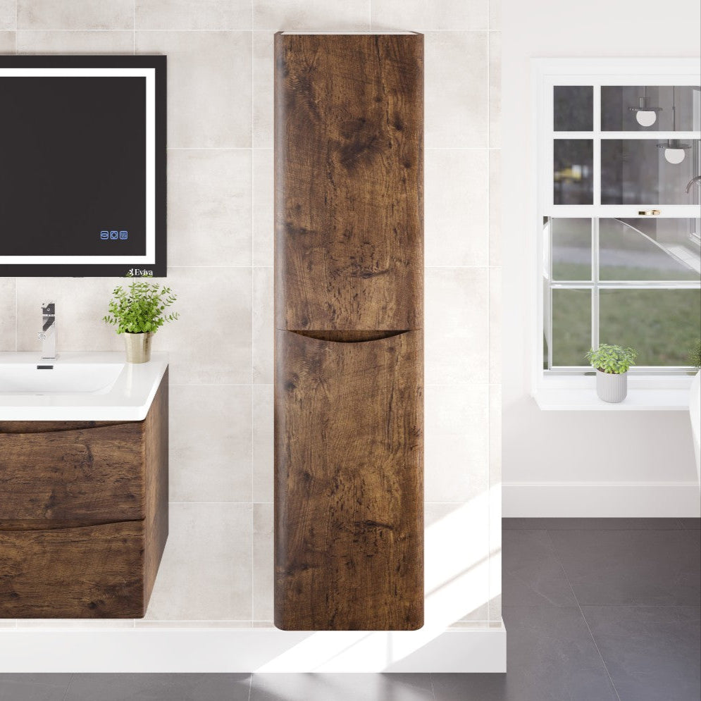 A rosewood wall-mounted linen cabinet with two doors and a sleek handle, shown in a bathroom setting with a sink and window in the background.