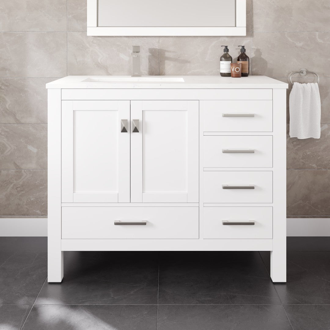 White bathroom vanity with sink and mirror in a tiled bathroom setting