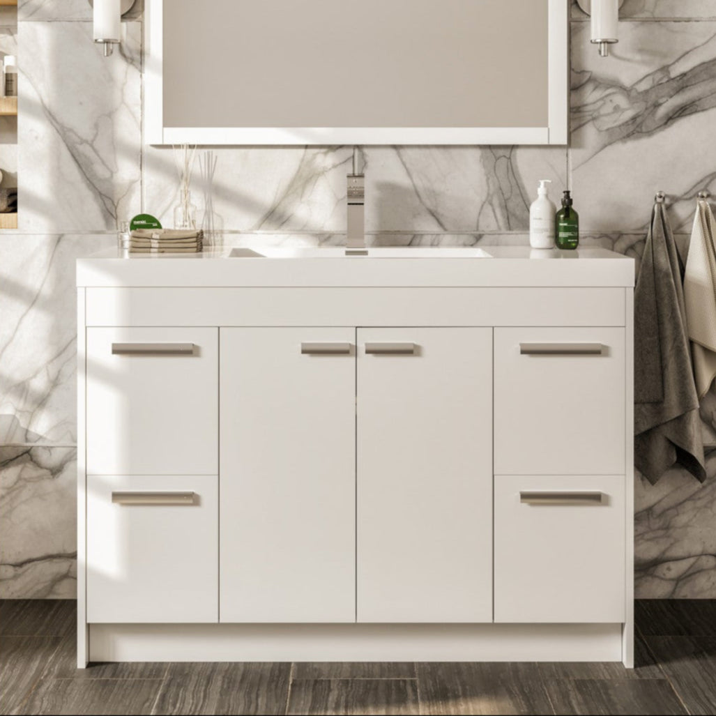 A modern white single sink bath vanity with an acrylic top and integrated sink, featuring a mirror above and towels to the side.