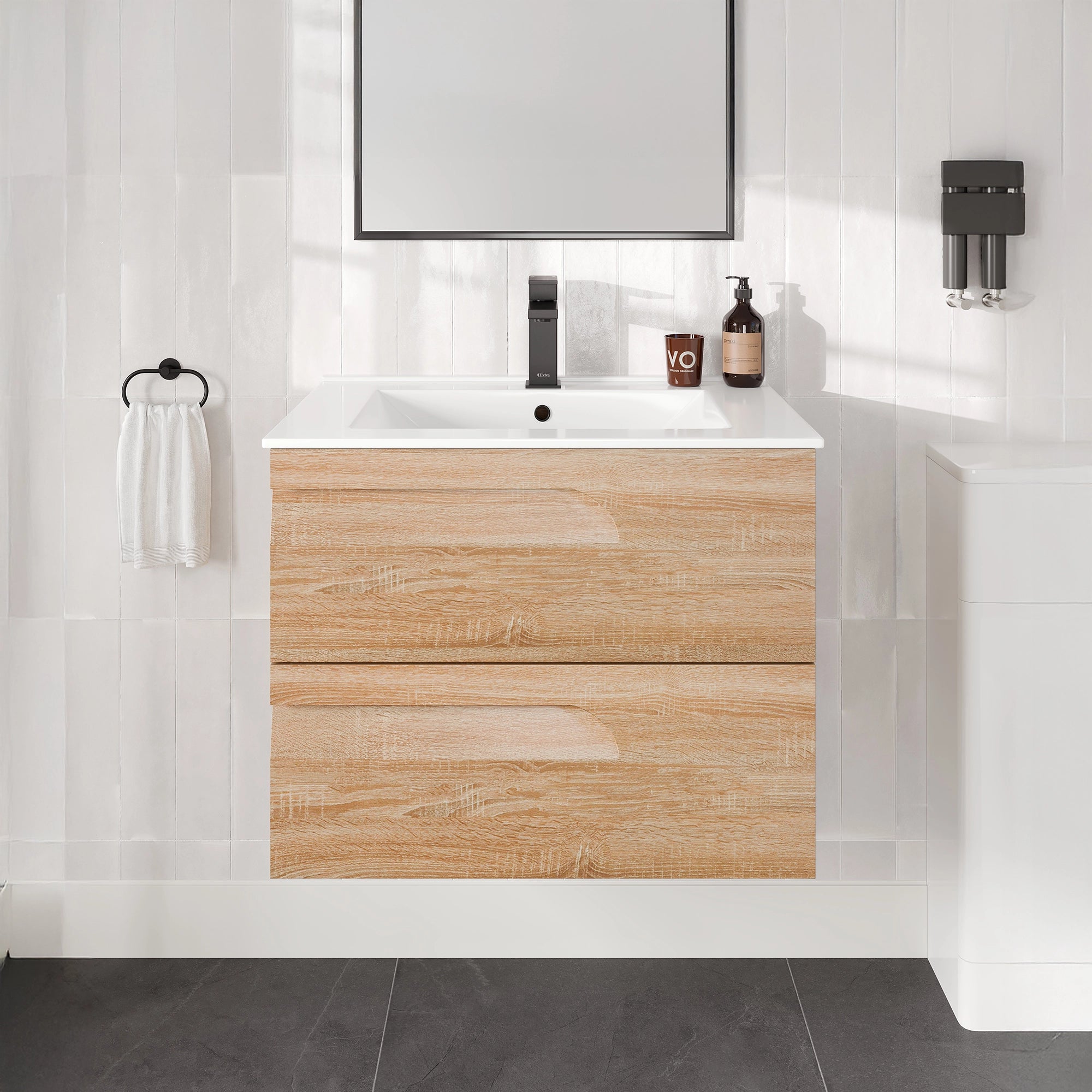 Bathroom vanity with wooden cabinet, sink, and mirror in a tiled bathroom.