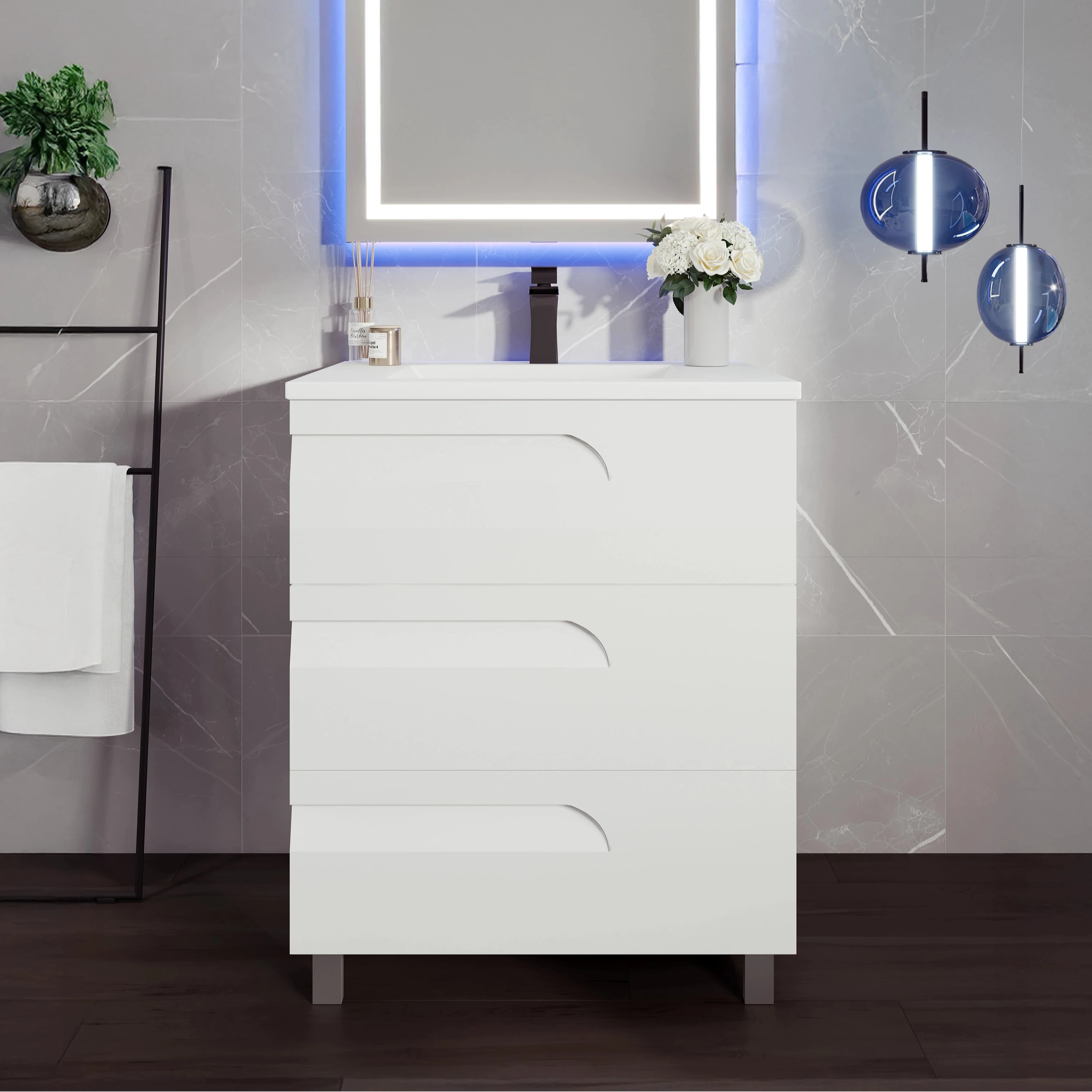 A modern white single sink bath vanity with an integrated sink and porcelain top, displayed in a bathroom setting with decorative items and a illuminated mirror.